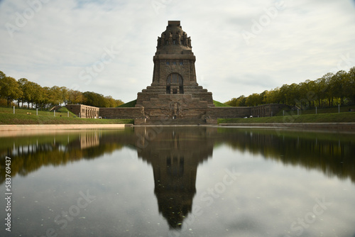 Pond reflecting the Monument to the Battle of the Nations in Leipzig  Germany against a cloudy sky