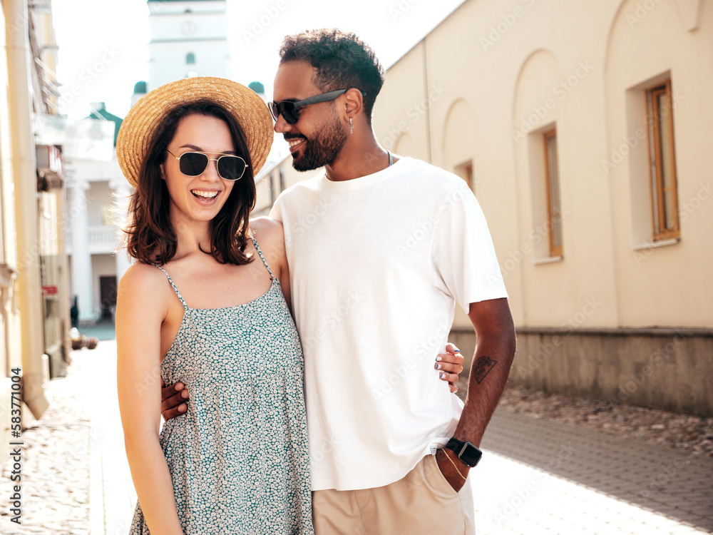 Smiling beautiful woman and her handsome boyfriend. Woman in casual summer clothes. Happy cheerful family. Female having fun. Sexy couple posing in the street at sunny day. In hat and sunglasses