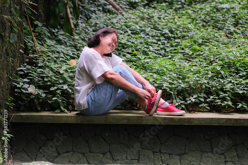 Woman sitting alone in the garden making private phone call photo