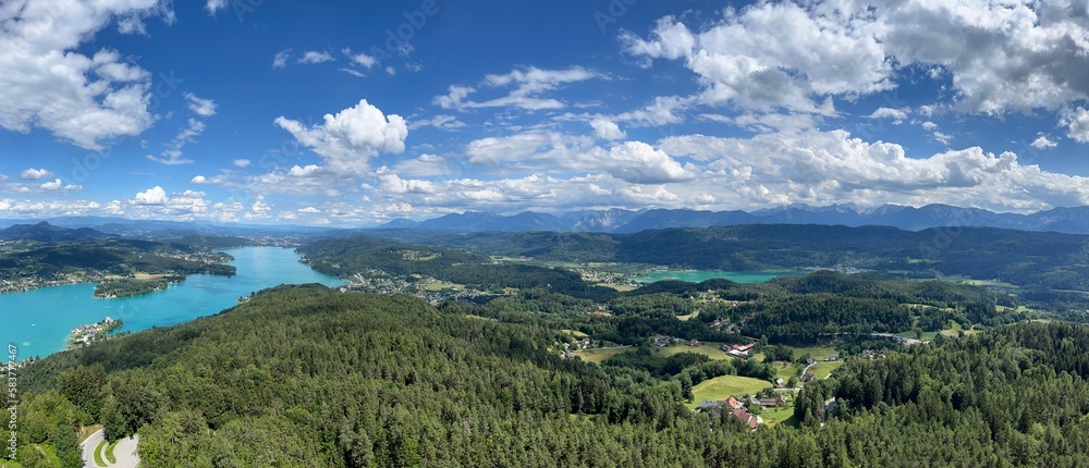 Turquoise waters of Lake Wörthersee to the left and the smaller Lake Keutschach on the right with the Karawank mountain range in the background