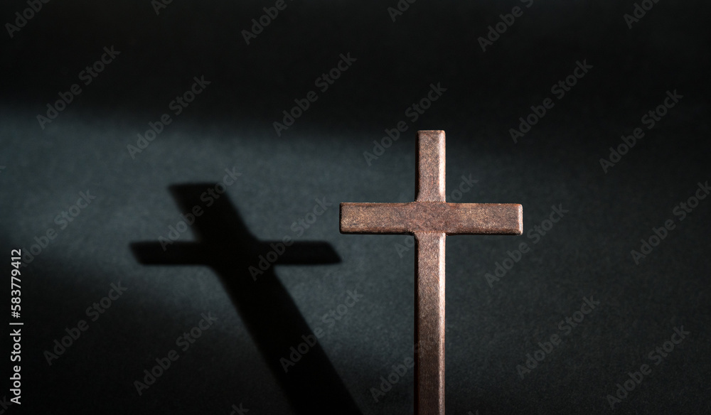 Crucifix wooden cross isolated on dark background. Copy space.