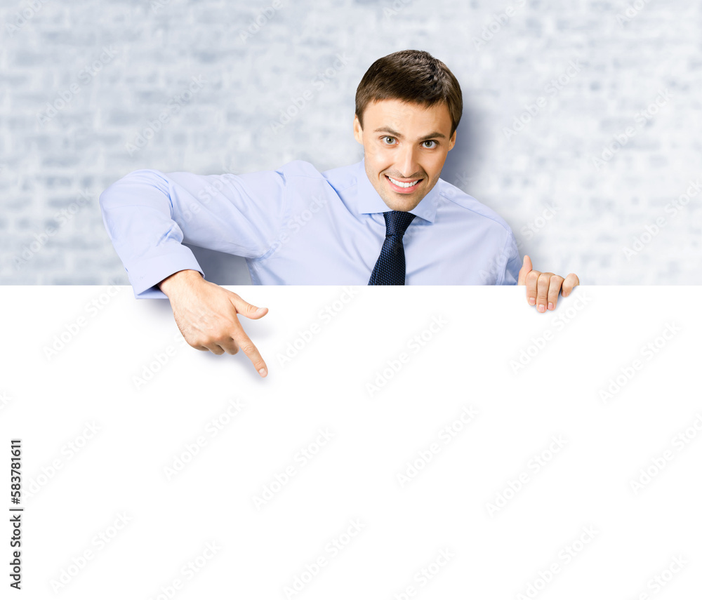 Portrait image of business man professional bank manager in confident cloth. Businessman stand behind, hang over, show point finger empty white banner signboard. White bricks wall background Portrait image of business man professional bank manager in confident cloth. Businessman stand behind, hang over, show point finger empty white banner signboard. White bricks wall background