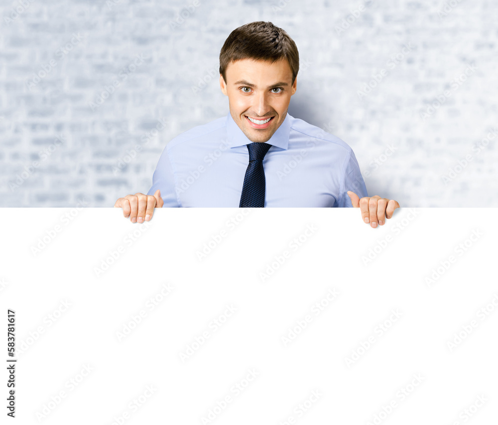 Portrait image of business man professional bank manager in confident cloth. Businessman stand behind hang over empty white banner signboard with copy space. White bricks wall background Portrait image of business man professional bank manager in confident cloth. Businessman stand behind hang over empty white banner signboard with copy space. White bricks wall background