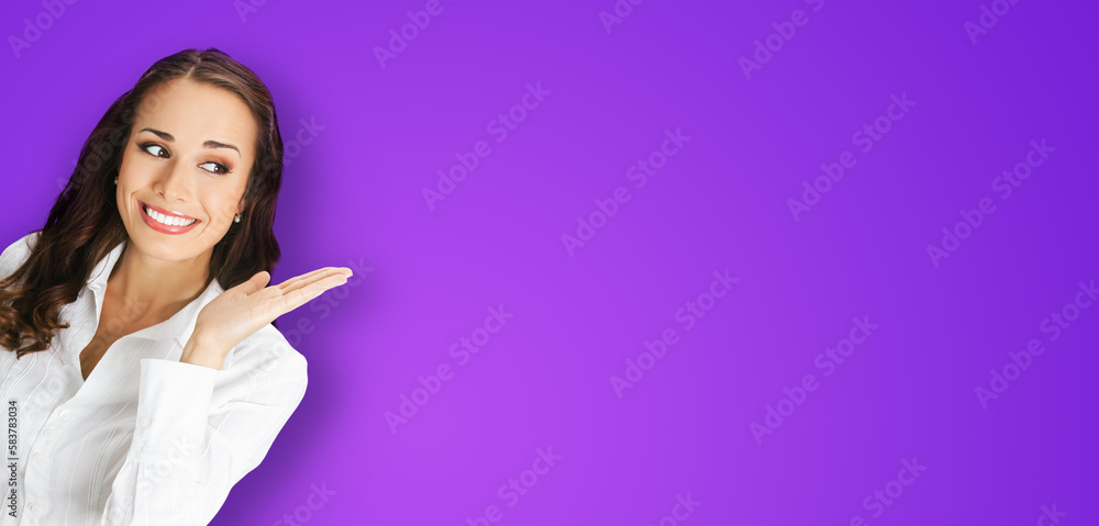 Happy smiling woman in confident blouse giving, holding, showing, advertising some product or copy space. Business advertisement concept. Brunette businesswoman, isolated violet purple background. Happy smiling woman in confident blouse giving, holding, showing, advertising some product or copy space. Business advertisement concept. Brunette businesswoman, isolated violet purple background.
