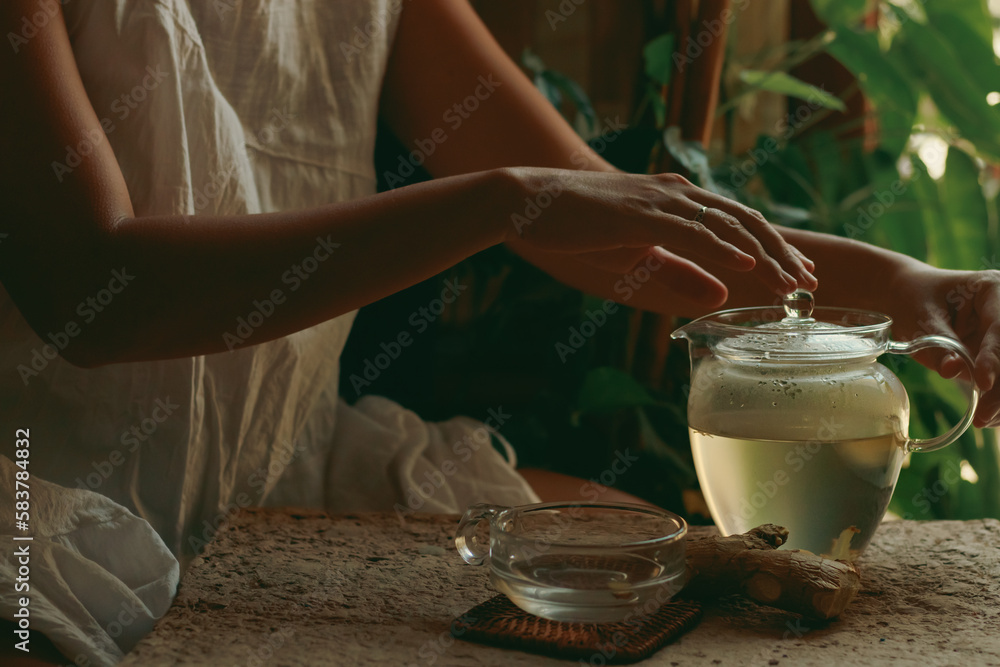 Woman preparing a pot of ginger infusion as part of a healthy morning routine, showing slow living, wellness and holistic healing - obrazy, fototapety, plakaty 