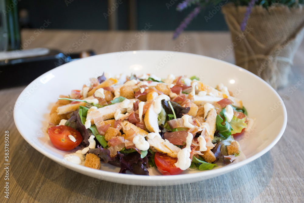 A Caesar salad is a salad of romaine lettuce, croutons, and chicken with lemon juice, olive oil, egg, Worcestershire sauce, anchovies, garlic, Dijon mustard, Parmesan cheese, and black pepper. A Caesar salad is a salad of romaine lettuce, croutons, and chicken with lemon juice, olive oil, egg, Worcestershire sauce, anchovies, garlic, Dijon mustard, Parmesan cheese, and black pepper.