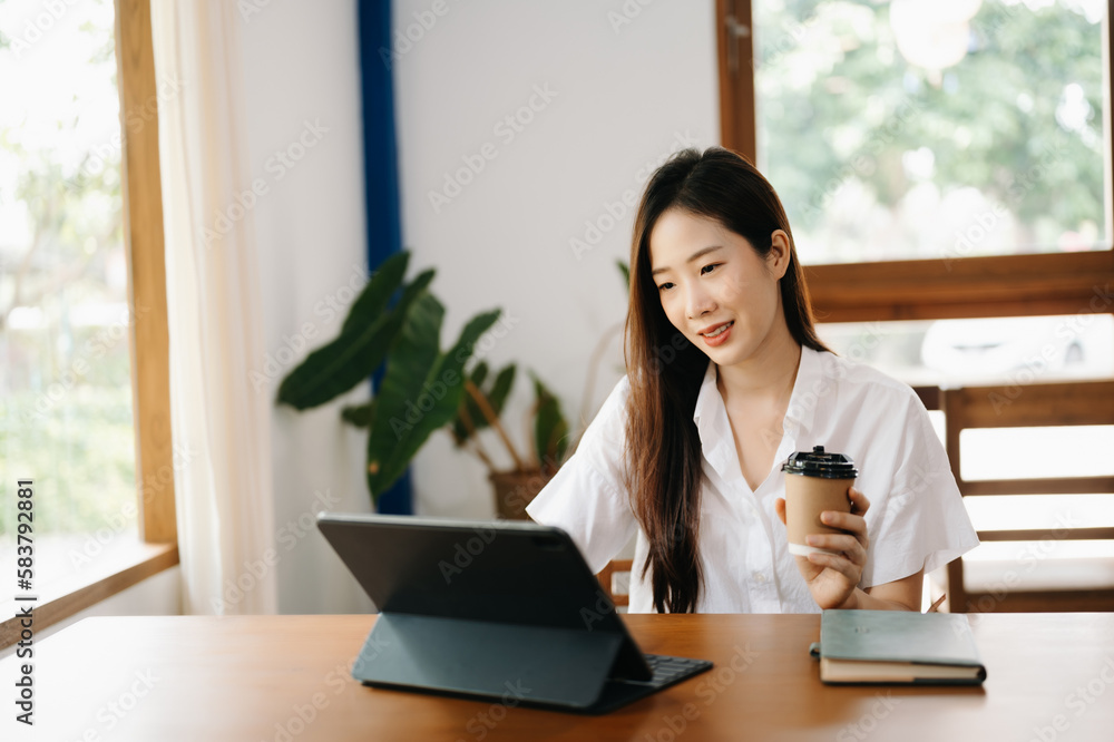 Asian woman working in the office with working notepad, tablet and laptop documents Asian woman working in the office with working notepad, tablet and laptop documents