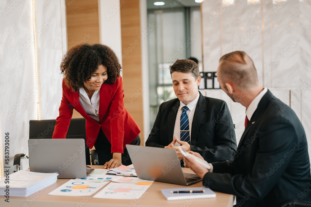 Happy businesspeople while collaborating on a new project in an office. Group of diverse businesspeople using a laptop and tablet in office.. Happy businesspeople while collaborating on a new project in an office. Group of diverse businesspeople using a laptop and tablet in office..