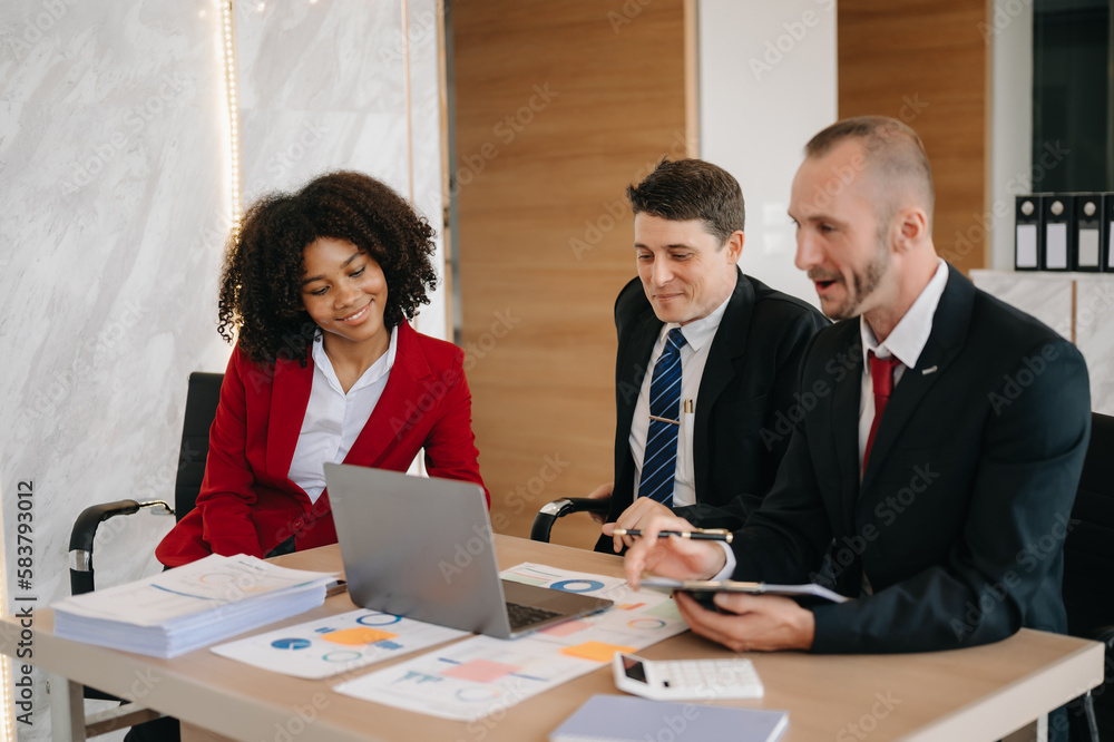 Happy businesspeople while collaborating on a new project in an office. Group of diverse businesspeople using a laptop and tablet in office.. Happy businesspeople while collaborating on a new project in an office. Group of diverse businesspeople using a laptop and tablet in office..