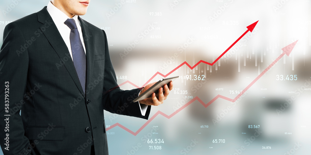 Close up of businessman hand holding tablet with growing red business chart arrow on blurry office interior background. Finance, profit and increase concept. Close up of businessman hand holding tablet with growing red business chart arrow on blurry office interior background. Finance, profit and increase concept.