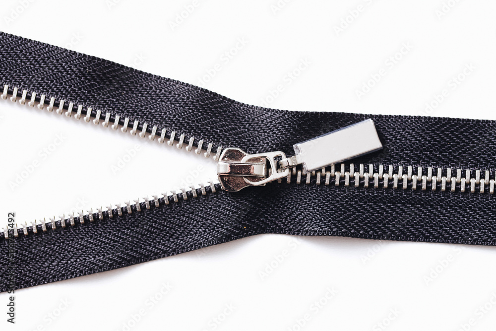 Metal zipper isolated on white. Tailoring object. Clothing part element. Object cutout on white. Fastener fashion background. Zipped part. Garment sewing zipper. Black color. Metal zipper isolated on white. Tailoring object. Clothing part element. Object cutout on white. Fastener fashion background. Zipped part. Garment sewing zipper. Black color.