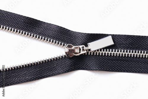 Metal zipper isolated on white. Tailoring object. Clothing part element. Object cutout on white. Fastener fashion background. Zipped part. Garment sewing zipper. Black color.