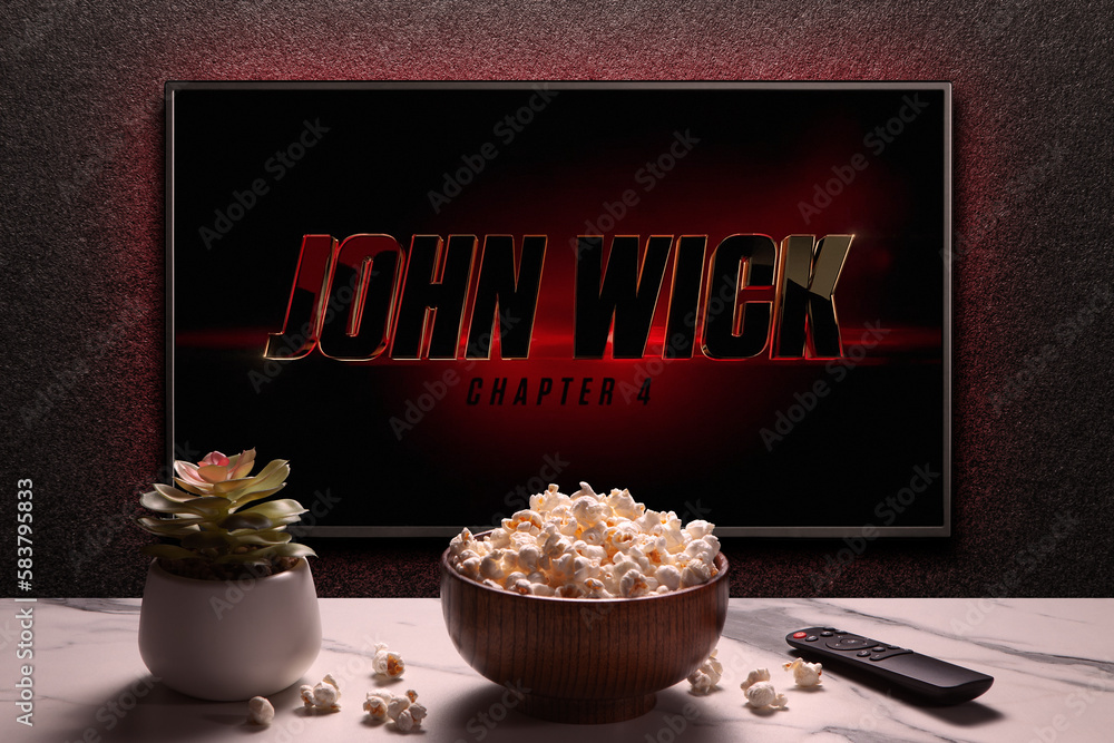 TV screen playing John Wick Chapter 4 trailer or movie. TV with remote