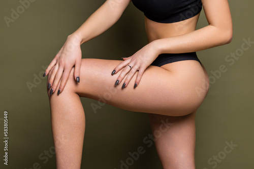 Cropped shot of young woman in black panties with slender toned figure isolated on a white background. Result of fitness, diet, healthy lifestyle. Female perfect body
