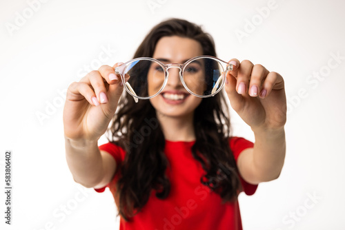Smiling brunette woman in eyeglasses over white background
