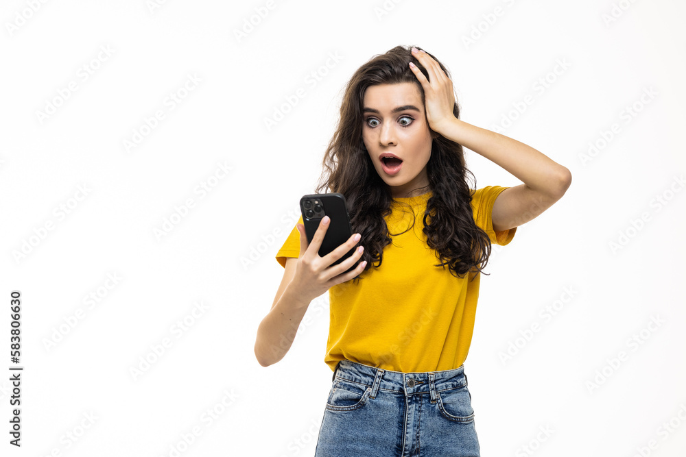 Portrait of a shocked businesswoman using mobile phone isolated over white background