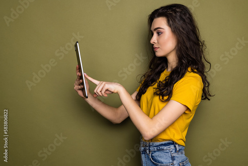 Photo of young woman hold tablet isolated on khaki color background