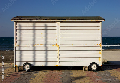 Mobile food vechile on the seaside. White food caravan stays closed during winter season in the coastline and started to mold slowly. photo