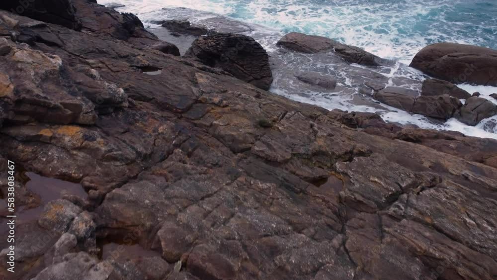 Rocky Shore With Foamy Waves Crashing In Arteixo Beach In La Coruna, Galicia, Spain. Topdown, Closeup Rocky Shore With Foamy Waves Crashing In Arteixo Beach In La Coruna, Galicia, Spain. Topdown, Closeup