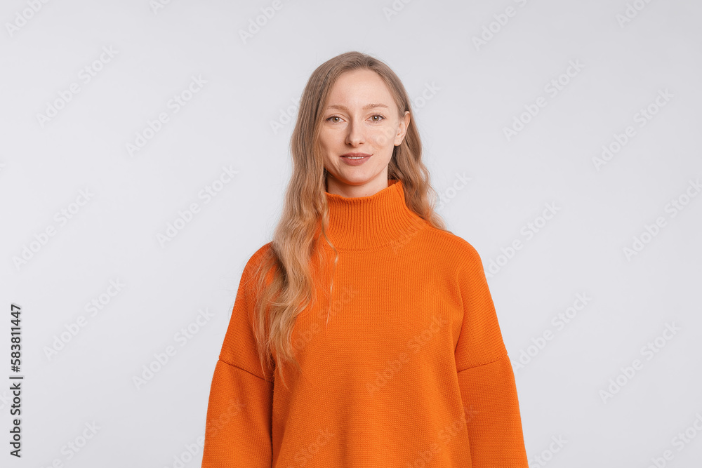 Portrait of attractive cute cheerful girl wearing soft orange sweater, standing over neutral background Portrait of attractive cute cheerful girl wearing soft orange sweater, standing over neutral background