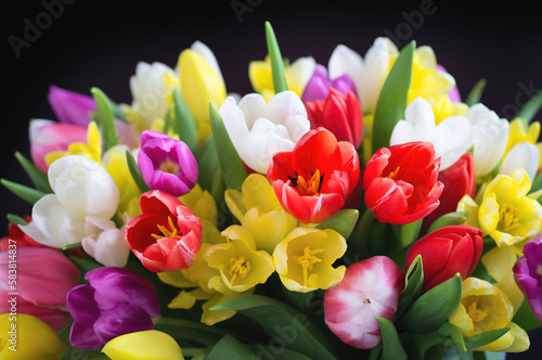 A vibrant bouquet of multi-colored spring flowers against a black background. Generative AI.