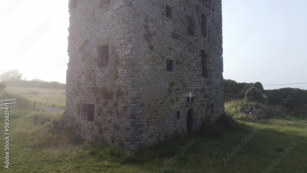 Carrigaholt Castle in sea fog climbing drone shot of the most haunted castle in Clare Ireland Carrigaholt Castle in sea fog climbing drone shot of the most haunted castle in Clare Ireland