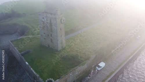 Drone panning Carrigaholt Castle and Fishing Harbour in a drifting sea fog photo