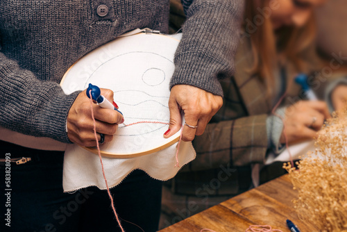Punch Needle Workshop. Needlework. Teacher shows how to knit with needle and frame.
