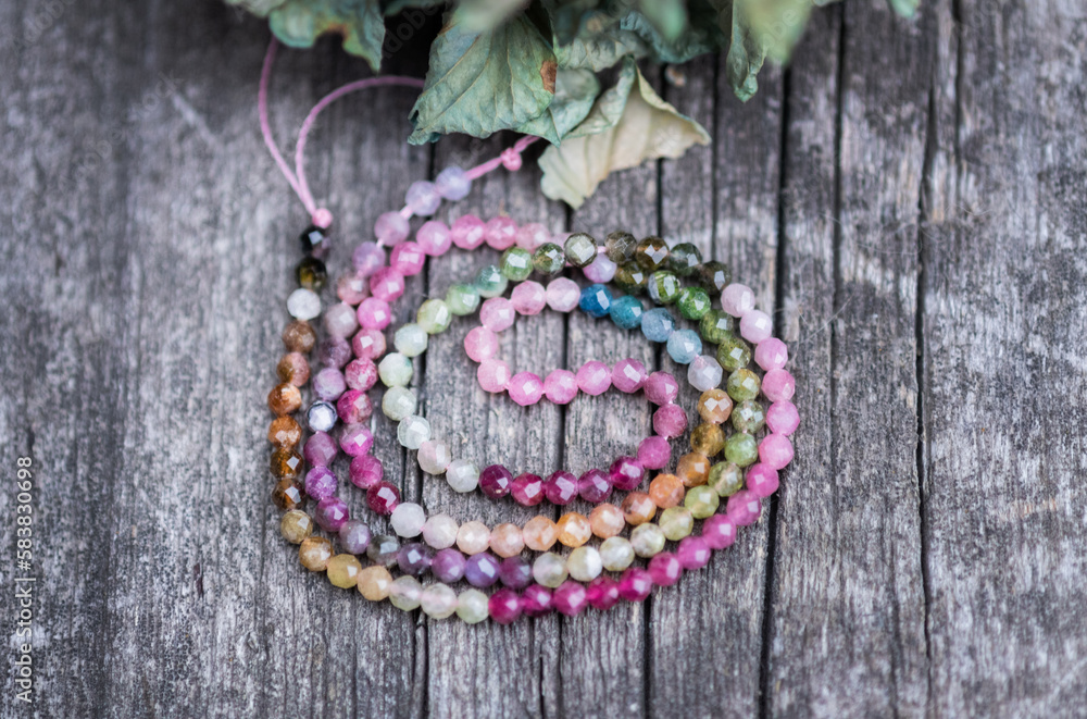 The photo with stones of colored tourmaline is made on the background of a wooden board and dried hydrangea. The photo with stones of colored tourmaline is made on the background of a wooden board and dried hydrangea.