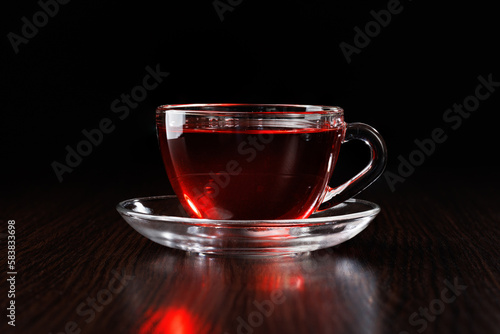 Glass cup with hot tea on a black background. Place for text, copy space.