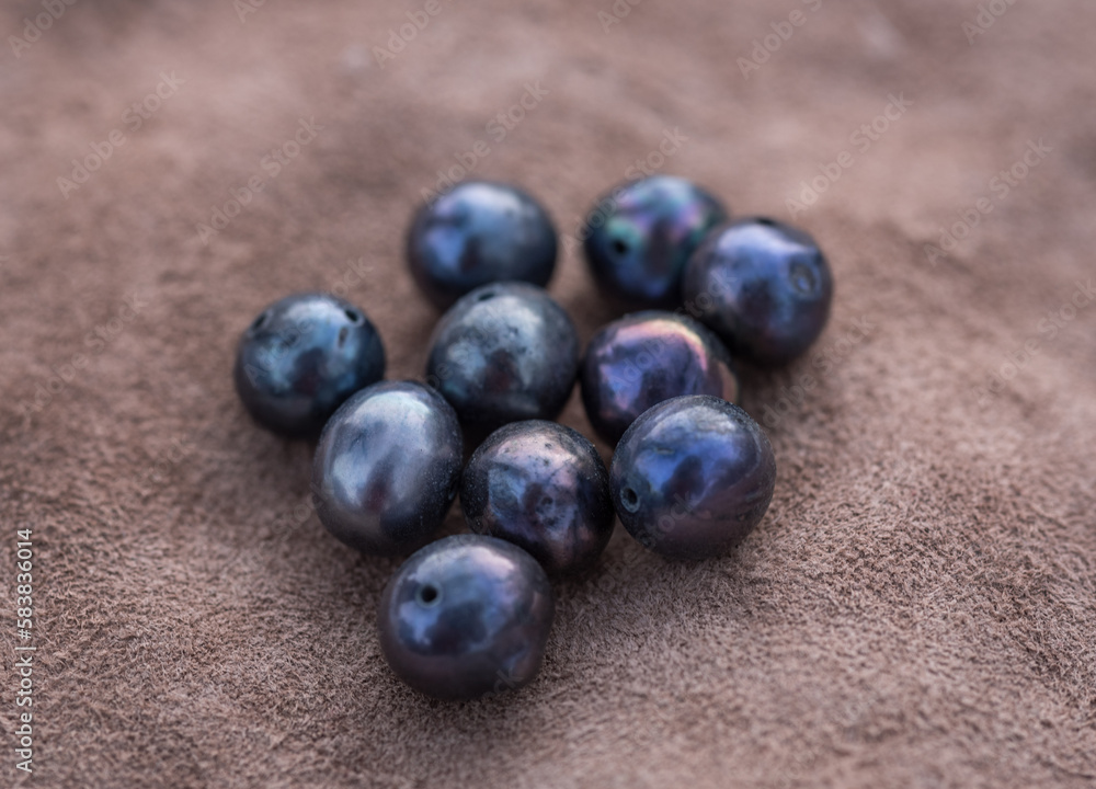 Natural freshwater pearls of various shapes and colors are photographed on a wooden board Natural freshwater pearls of various shapes and colors are photographed on a wooden board