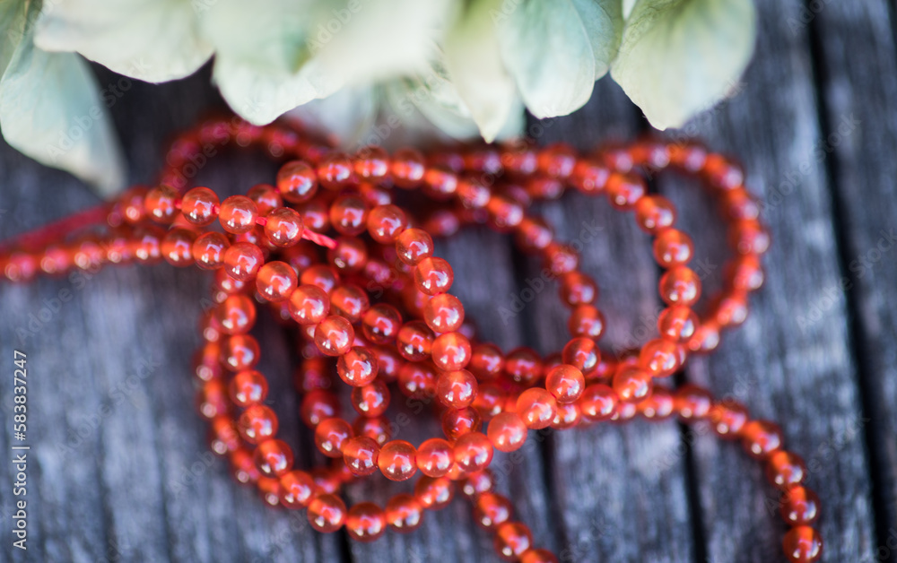 The photo with red agate stones is made on the background of a wooden board and dried hydrangea. The photo with red agate stones is made on the background of a wooden board and dried hydrangea.