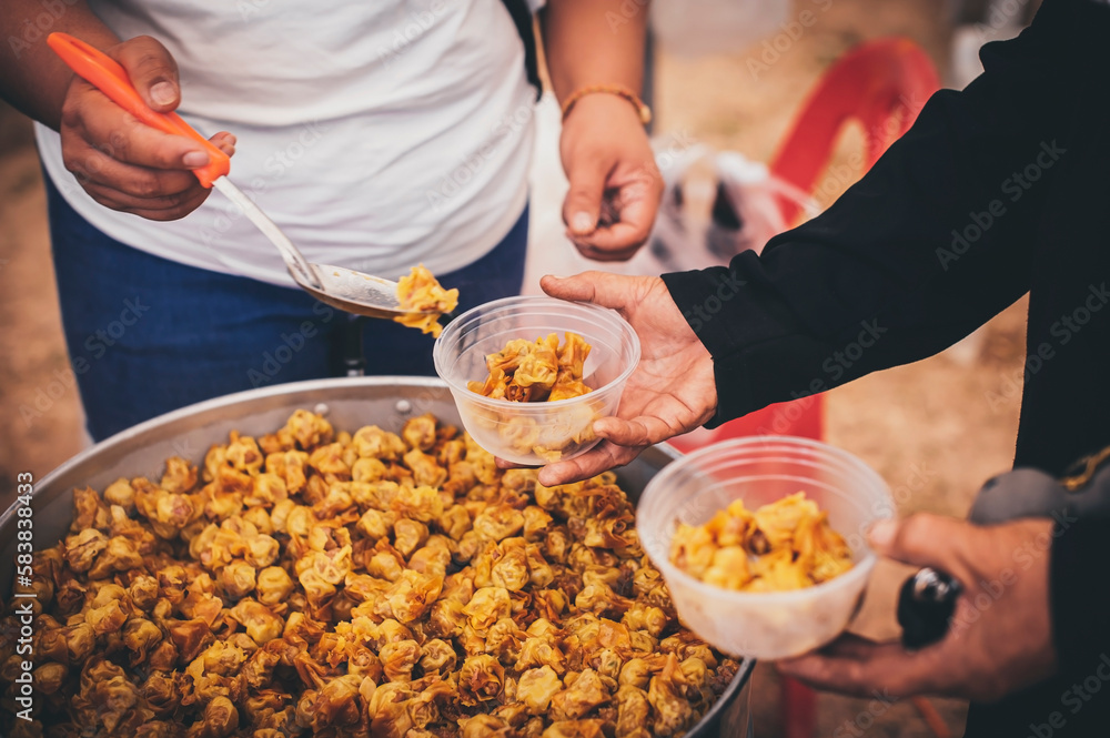 Volunteers distribute simple meals to the poor at the free food kitchen. Volunteers distribute simple meals to the poor at the free food kitchen.