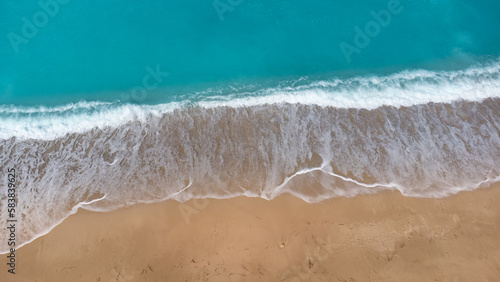 Aerial view of beautiful sandy beach and soft turquoise ocean wave. Tropical sea in summer season on Megali Petra beach on Lefkada island.