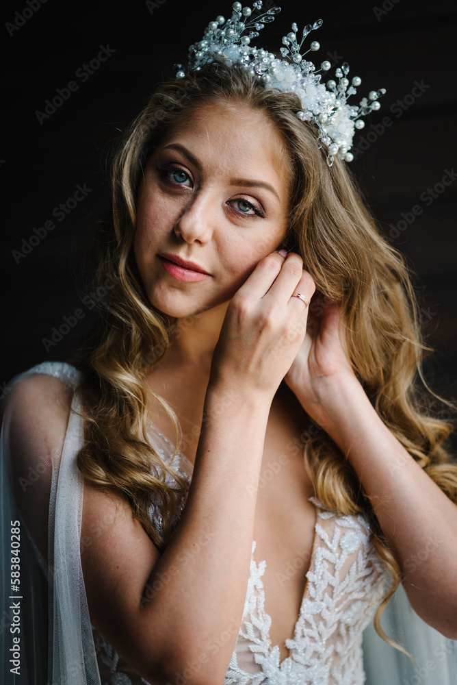 The bride in a white dress wears gold earrings with pearls. In the hands of the bride decoration in the form of a earring. Wedding Morning. Jewelry. Close-up makeup. The bride in a white dress wears gold earrings with pearls. In the hands of the bride decoration in the form of a earring. Wedding Morning. Jewelry. Close-up makeup.