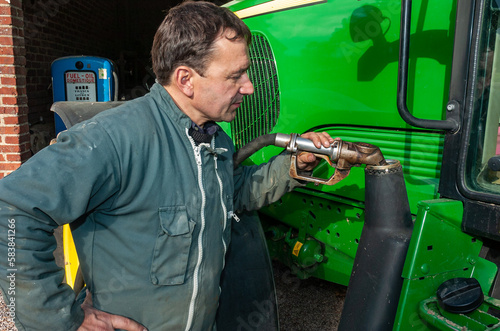 Agriculteur effectuant le plein de gas-oil de son tracteur photo