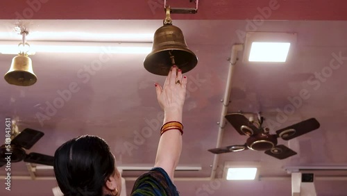 devotee ringing the holly bell at temple at morning photo