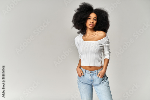 Attractive african american girl with an afro hairstyle isolated on gray background