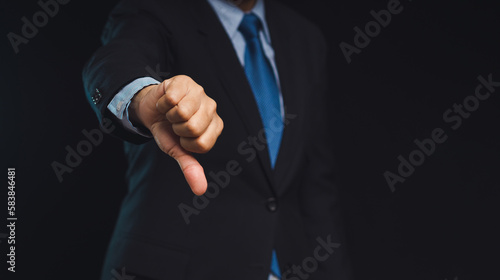 Negative concept. Close-up of businessman's hand showing a thumbs down for dislike service © meeboonstudio
