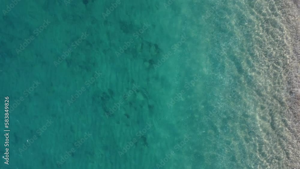 Aerial view of beautiful sandy beach with footprints and soft turquoise ocean wave. Tropical sea in summer season on Kathisma beach on Lefkada island. Aerial view of beautiful sandy beach with footprints and soft turquoise ocean wave. Tropical sea in summer season on Kathisma beach on Lefkada island.