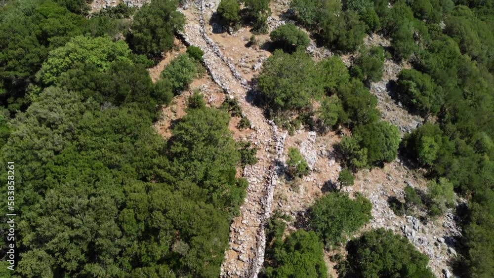 Rocky Trail To The Askifou Fortress Ruins With Green Trees On Slope In Greece. - aerial tilt up Rocky Trail To The Askifou Fortress Ruins With Green Trees On Slope In Greece. - aerial tilt up