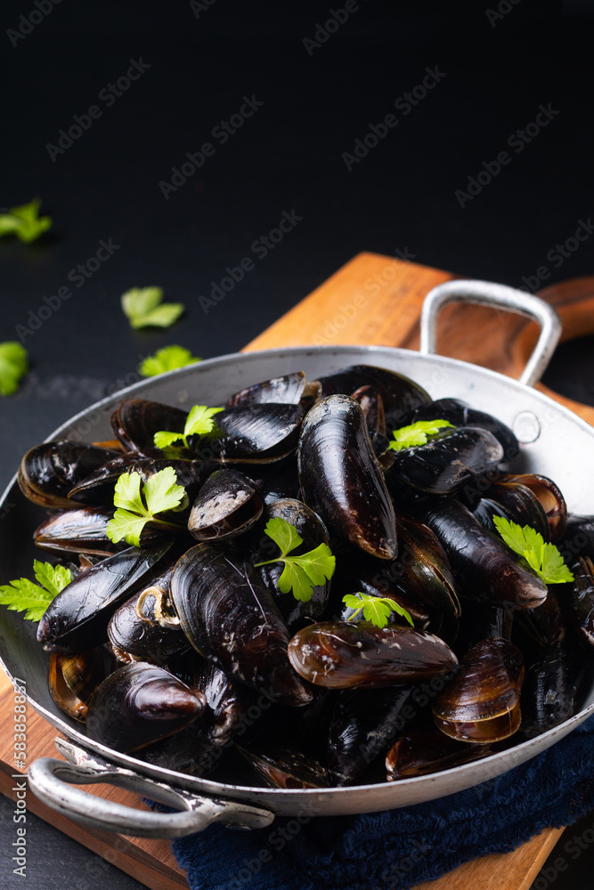 Food concept Fresh Mussels in the pan on black background with copy space Food concept Fresh Mussels in the pan on black background with copy space