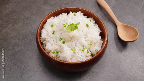 Hot cooked rice in brown wooden bowl