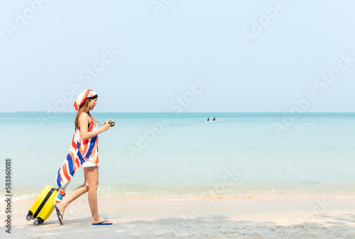 Summer vacations. Lifestyle woman talk a photo and relax chill on beach background. Asia happy young people with yellow suitcase fashion summer. Travel summer vacations, copy space