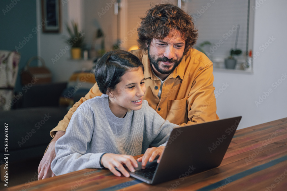 Man with his teenage daughter using laptop together at home Man with his teenage daughter using laptop together at home