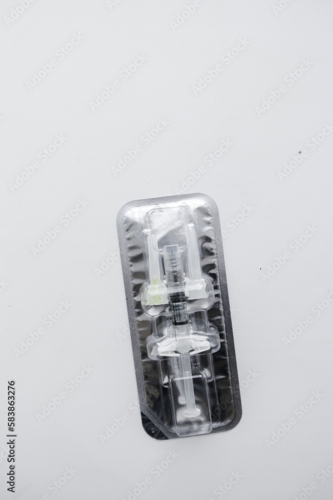 Injection syringe with collagen hyaluronic filler for facial or lip rejuvenation, close-up. syringe and two small needles in an individual package. The filler for the cosmetologist. Injection syringe with collagen hyaluronic filler for facial or lip rejuvenation, close-up. syringe and two small needles in an individual package. The filler for the cosmetologist.