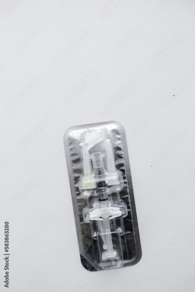 Injection syringe with collagen hyaluronic filler for facial or lip rejuvenation, close-up. syringe and two small needles in an individual package. The filler for the cosmetologist. Injection syringe with collagen hyaluronic filler for facial or lip rejuvenation, close-up. syringe and two small needles in an individual package. The filler for the cosmetologist.