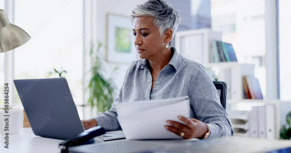Laptop, documents and review with a business woman at work in her office for a proposal or report. Computer, reading and paperwork with a serious female employee busy working on a research project