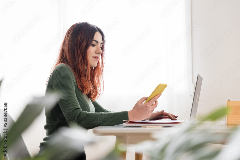 Young woman using smartphone and laptop Young woman using smartphone and laptop
