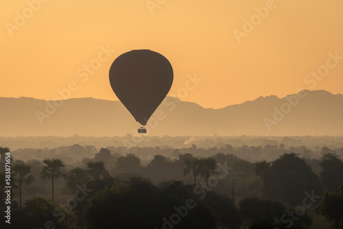 Hot-air balloon at sunrise against mountains, Bagan (Pagan) photo